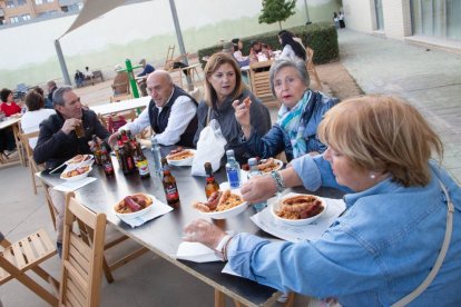 Varias personas degustando las migas con chorizo y torrezno.