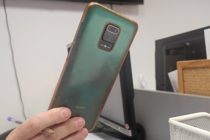 Una joven sostiene su teléfono móvil.