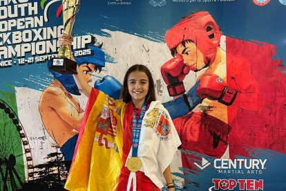 Adriana verde con su medalla de oro, el trofeo, la bandera de España y la de Soria.