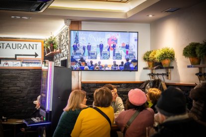 Personas siguiendo el sorteo en un bar de la capital.