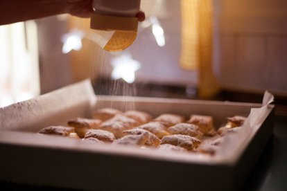 El toque final: una nube de azúcar glas transforma los cochinitos de hojaldre en el postre más esperado de la matanza soriana.