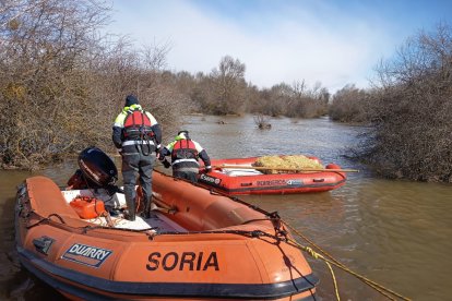 Los bomberos de Soria preparan una embarcación con efectivos y otra con alimento para una ganadería aislada por las inundaciones en Garray.