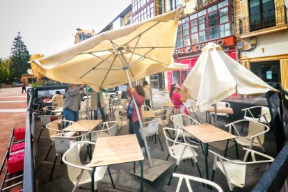 El viento afecta a las sombrillas de una terraza en el centro de Soria a primera hora de la tarde.