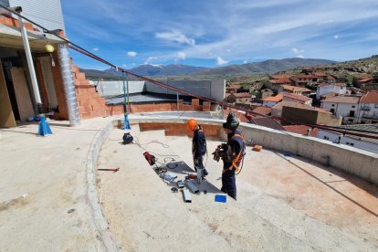 Dos trabajadores en plena tarea en la terraza del planetario de Borobia.