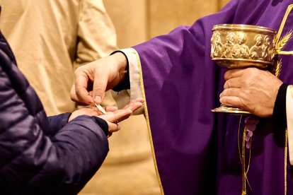 Un sacerdote dando la comunión a un feligrés en una imagen reciente.