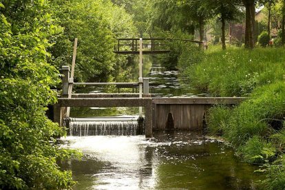 Canal de riego con tajadera para regular el acceso de agua.