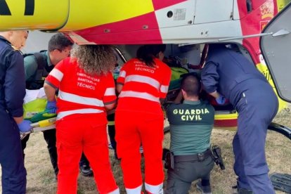Sanitarios, pilotos y Guardia Civil colaboran para introducir a la víctima en el helicóptero.