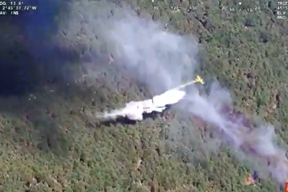 Un avión descarga sobre la zona del incendio forestal en Vinuesa.
