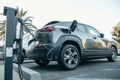Vehículo eléctrico moderno cargando en una estación exterior
