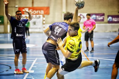 Un jugador del BM Soria trata de fajarse de un rival en una acción del partido.