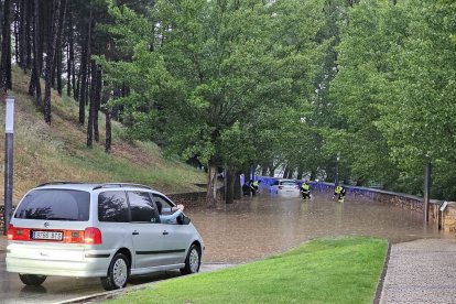 Un vehículo espera ante la balsa en la que ha quedado atrapado un coche a modo de tpón para el tráfico en el Soto Playa de Soria. GONZALO MONTESEGURO