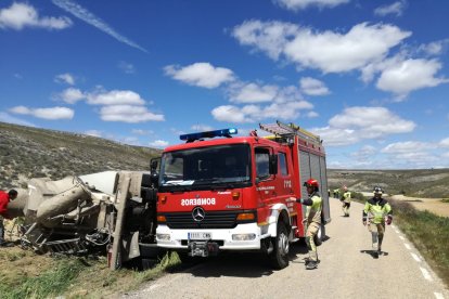 Los bomberos intervienen en el camión siniestrado.