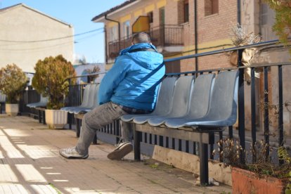 Un vecino sentado en una de las sillas colocadas por la localidad.