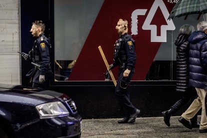 Un agente de la Policía Nacional se dirige al vehículo policial con un palo de tamaño considerable .