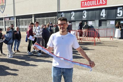 Un aficionado muestra sus entradas.