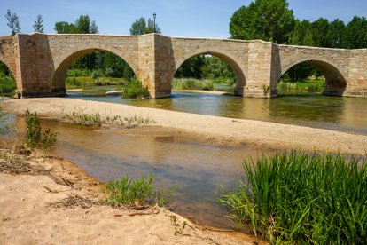 Tres de los doce arcos del Puente de Langa de Duero reflejados en el Duero, ejemplo de ingeniería medieval que aún hoy resiste el paso del agua y del tiempo.
