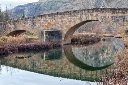 El Puente de El Burgo de Osma, con sus arcos de medio punto y tajamares en cuña, reflejado en el Ucero.