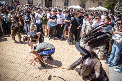 Zarrón azuzando a un joven que se agacha a por un caramelo.