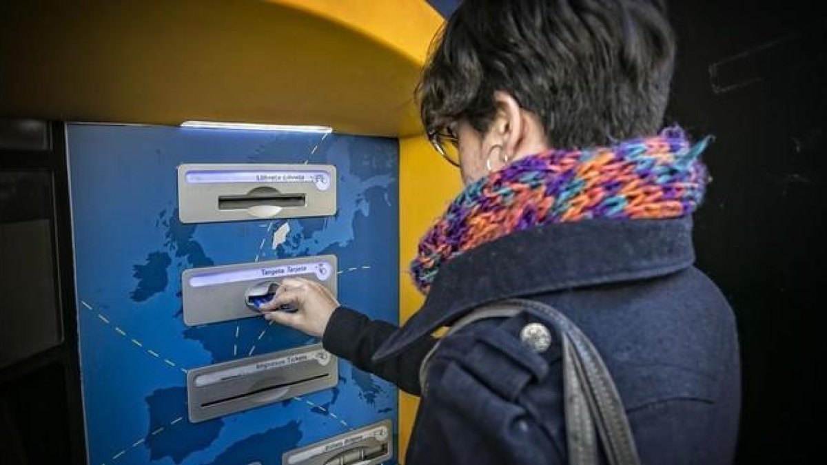 Una mujer saca dinero en un cajero automático.-OAN CORTADELLAS