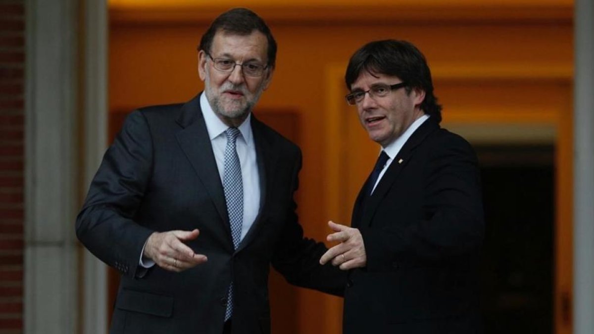 Mariano Rajoy y Carles Puigdemont se saludan antes de su reunión en la Moncloa.-DAVID CASTRO