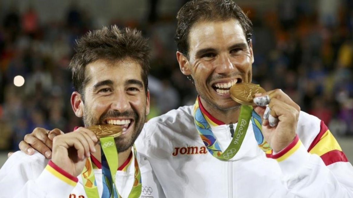 Marc López y Rafael Nadal muerden las medallas de oro.-REUTERS / KEVIN LAMARQUE