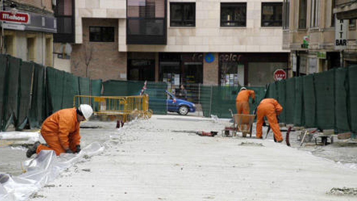 Operarios trabajan en las obras que se están realizando para el mercado provisional en la calle Sagunto de la capital soriana. / ÁLVARO MARTÍNEZ-