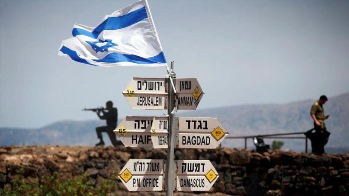 Un soldado israelí junto a un grupo de carteles que indican las distancias entre los Altos del Golán y varias ciudades de Oriente Próximo.-REUTERS / RONEN ZVULUN