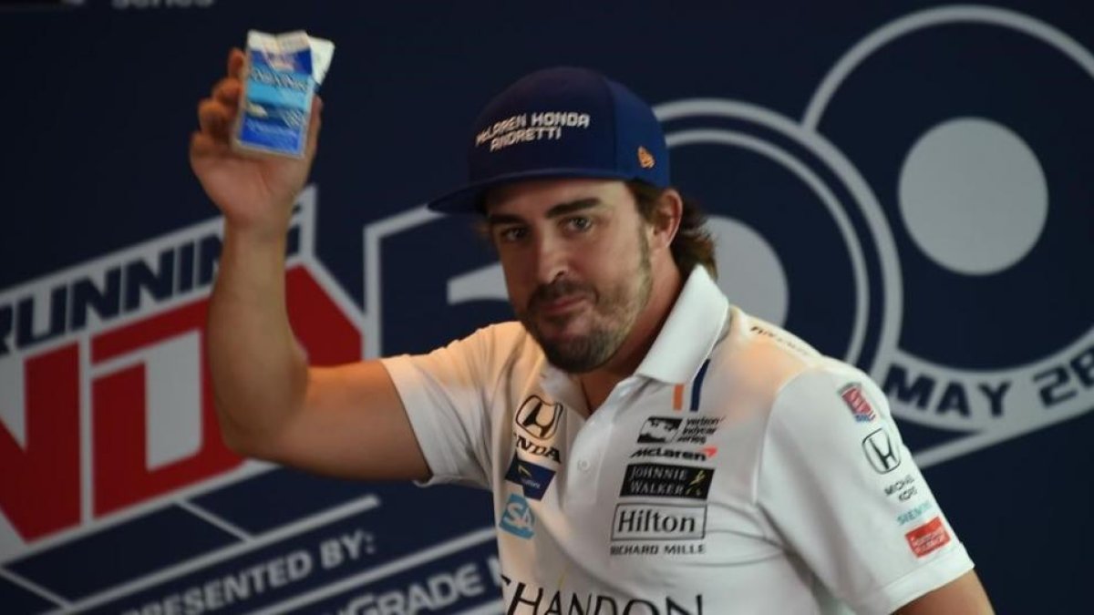 Fernando Alonso brinda con un brick de leche ante su eqUIPO.-