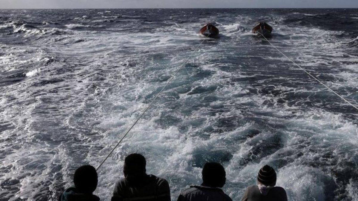 Inmigrantes en la popa del 'Golfo Azzurro', en dirección hacia Sicilia, al día siguiente de ser rescatados por la oenegé Proactiva Open Ams, el 3 de enero.-REUTERS / YANNIS BEHRAKIS