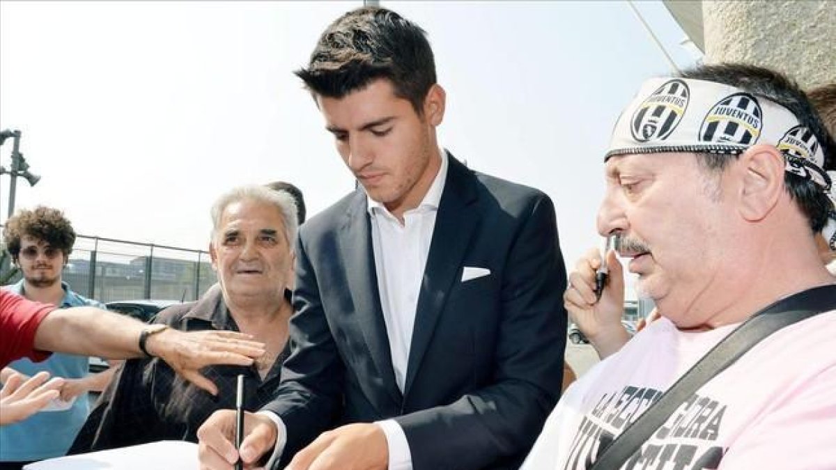 Morata firma autógrafos a los aficionados de la Juventus en Turín.-EFE / ALESSANDRO DI MARCO