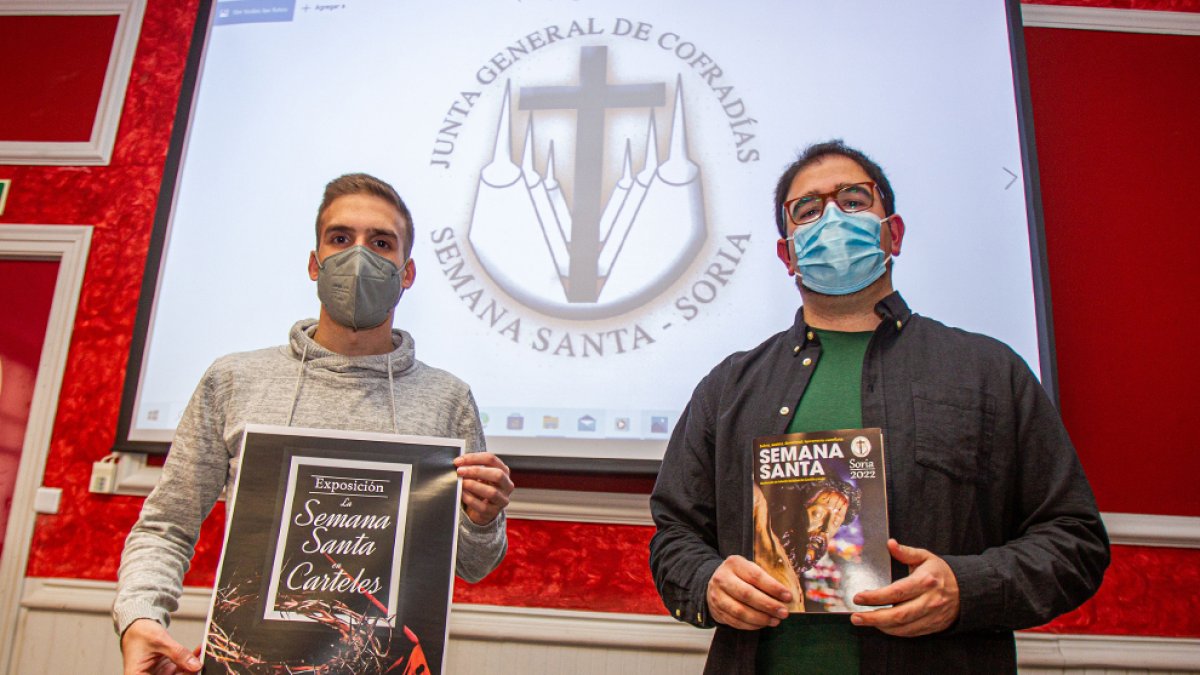 Adrián del Amo sostiene el póster de la exposición de carteles y Daniel Madrid con el programa. MARIO TEJEDOR