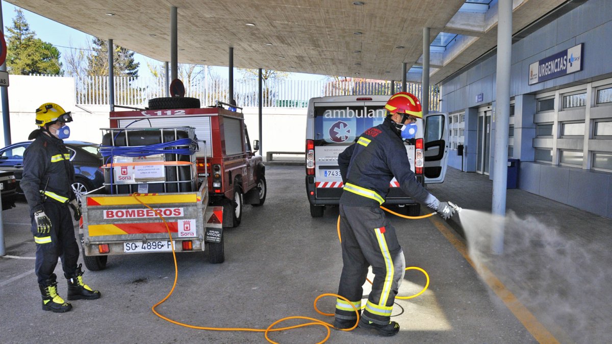 Los bomberos limpian los exteriores de Urgencias de Santa Bárbara.  VALENTÍN GUISANDE