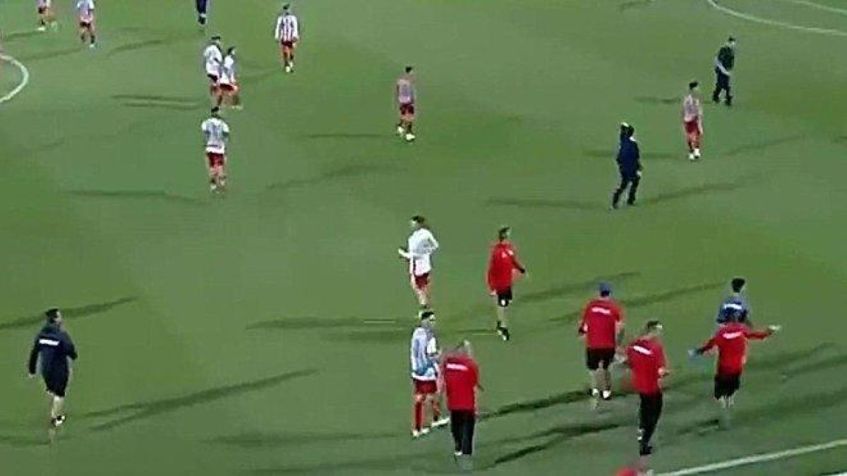 Jugadores y técnicos del Olympiacos y Bayern, concentrados en el centro del campo para esquivar a los violentos hinchas griegos.-