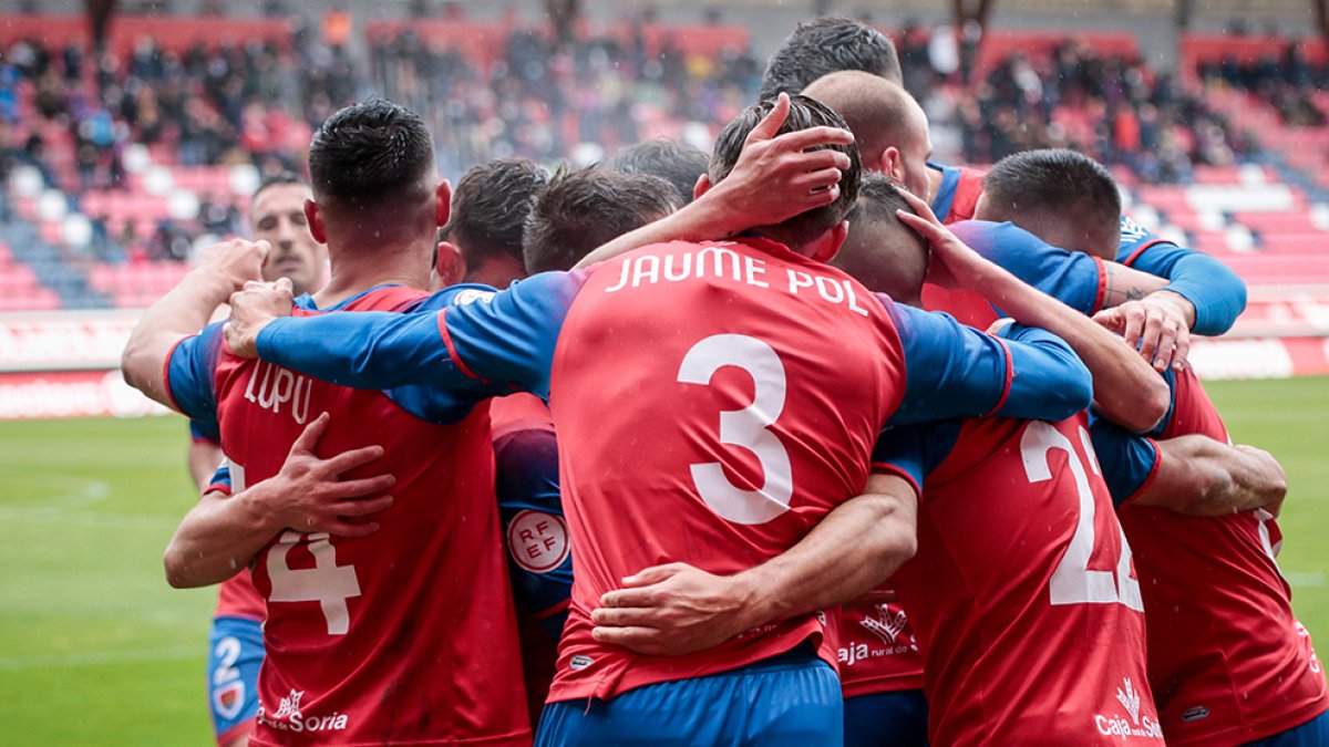 Jaume Pol se abraza con sus compañeros para celebrar un gol del Numancia esta temporada. GONZALO MONTESEGURO