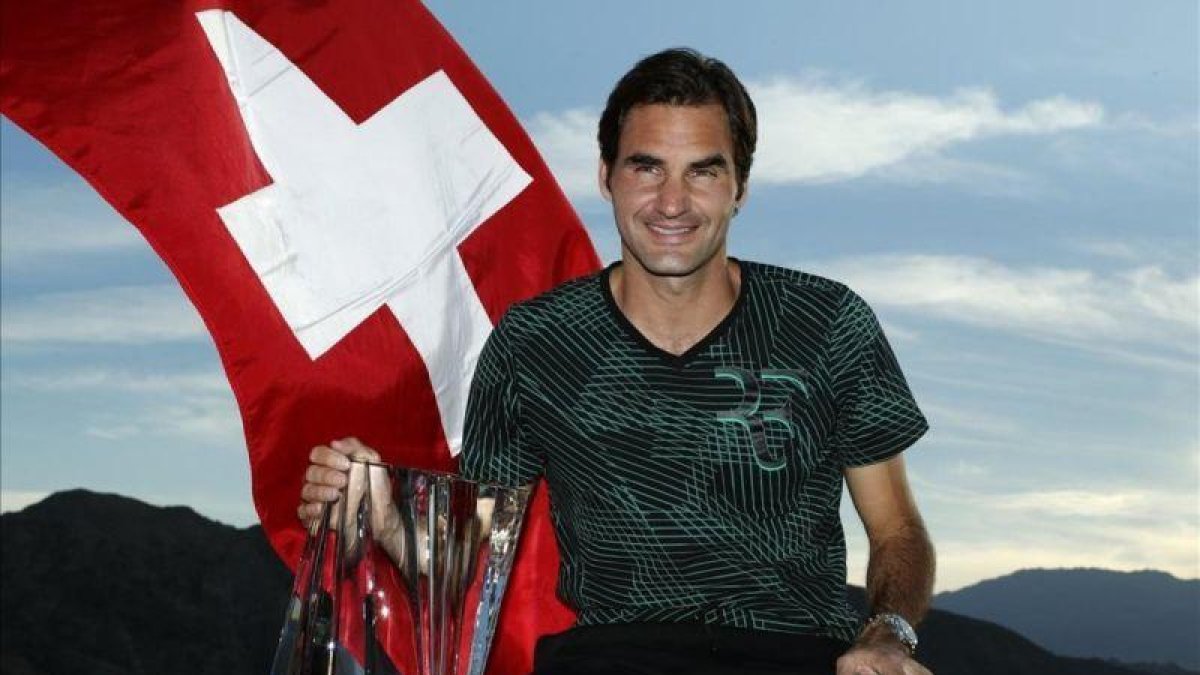 Federer posa para los fotógrafos con el trofeo de Indian Wells y la bandera suiza-PAUL BUCK / EFE