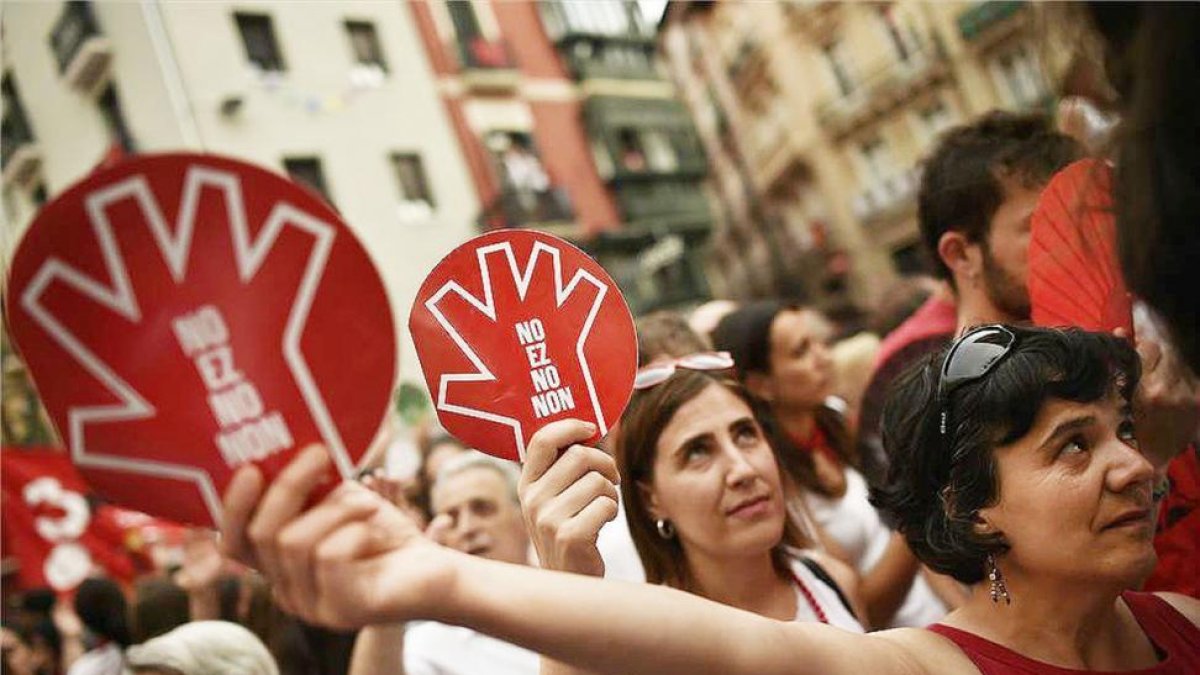 Unas mujeres muestran el símbolo de la campaña contra las agresiones sexistas en Sanfermines durante la manifestación ciudadana.-ÁLVARO BARRIENTOS (AP)