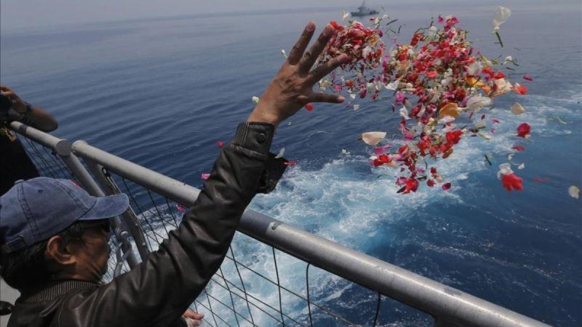Un familiar de una de las víctimas del accidente del avión de Lion Air lanza flores en las proximidades del lugar donde se produjo el siniestro, en Indonesia.-TATAN SYUFLANA (AP)