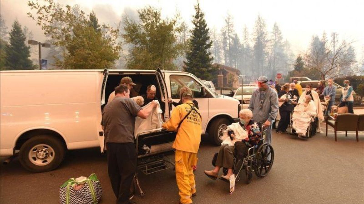 Miembros de los servicios de rescate trasladan a un grupo de personas lejos de los efectos de las llamas, en la localidad californiana de Paradise.-JOSH EDELSEN (AFP)