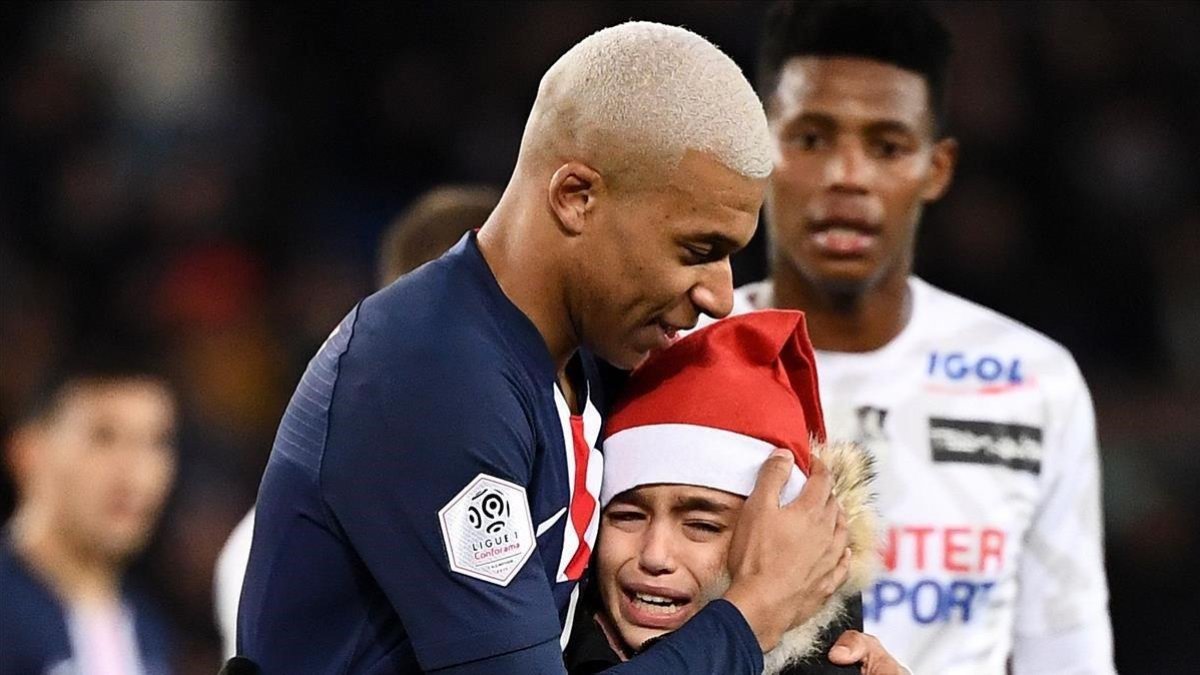 Mbappé abraza a un niño que le pidió un autógrafo en el partido contra el Amiens.-AFP / FRANCK FIFE