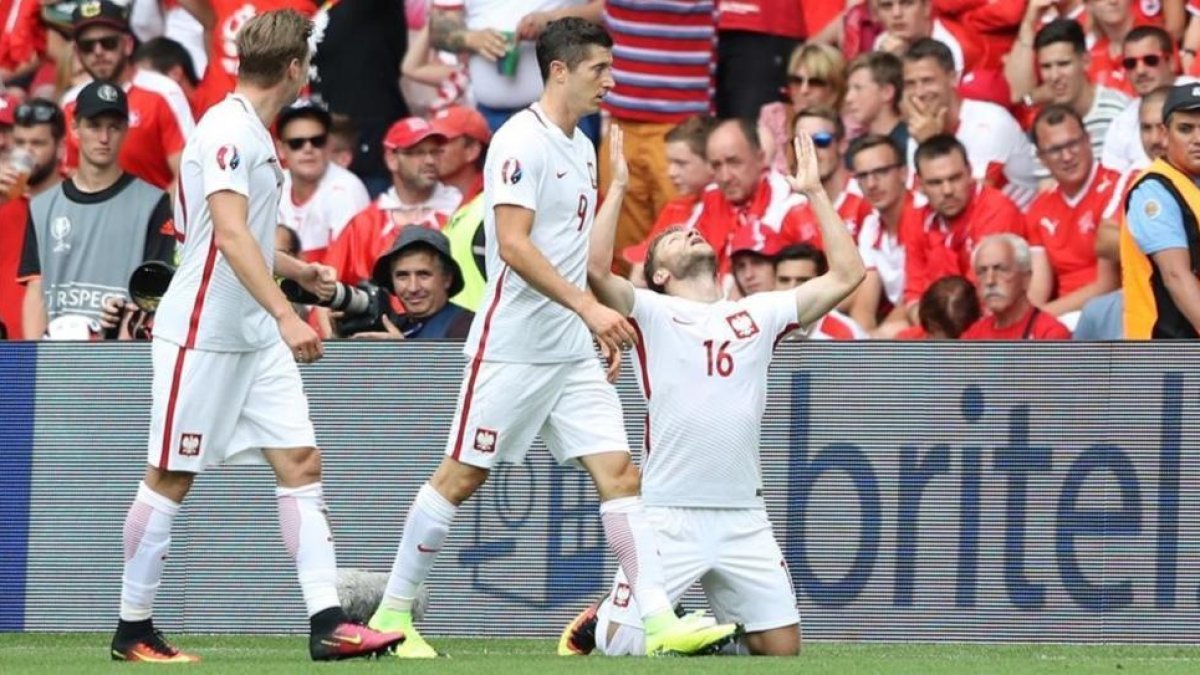 Blaszczykowski, arrodillado en el césped, celebra su gol a Suiza junto a Lewandowski.-Laurent Cipriani