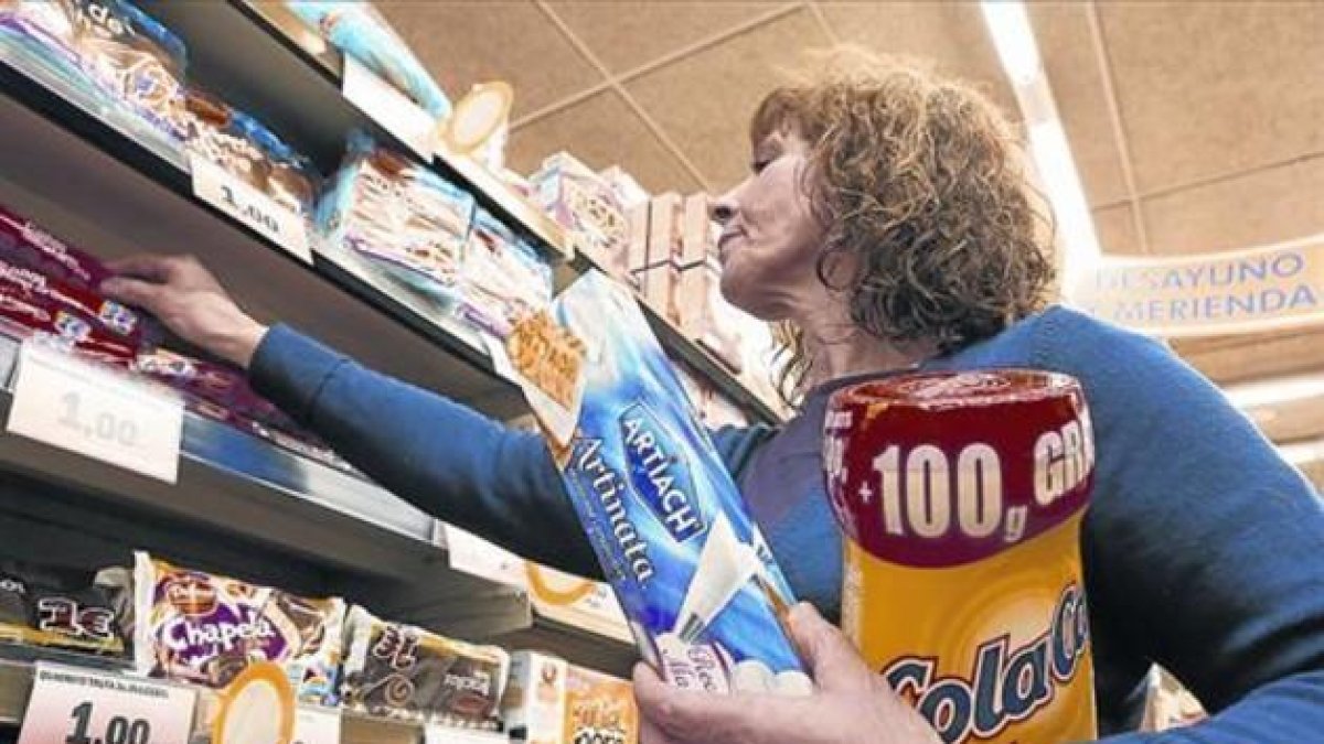 Una mujer compra Cola Cao  en un supermercado.-FERRAN NADEU