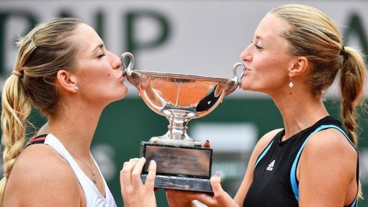 Kristina Mladenovic (derecha) y Timea Babos besan el trofeo de campeonas de dobles de Roland Garros.-AFP / MARTIN BUREAU