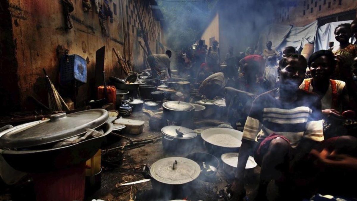 Un grupo de refugiados cocinando en un campamento de Bouca, en Republica Centroafricana.-EFE / JUAN CARLOS TOMASI