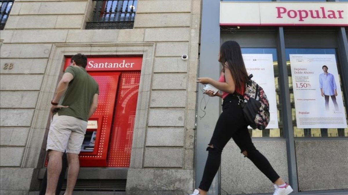 Oficina del Banco Santander junto a una del Popular en Madrid.-JUAN MANUEL PRATS