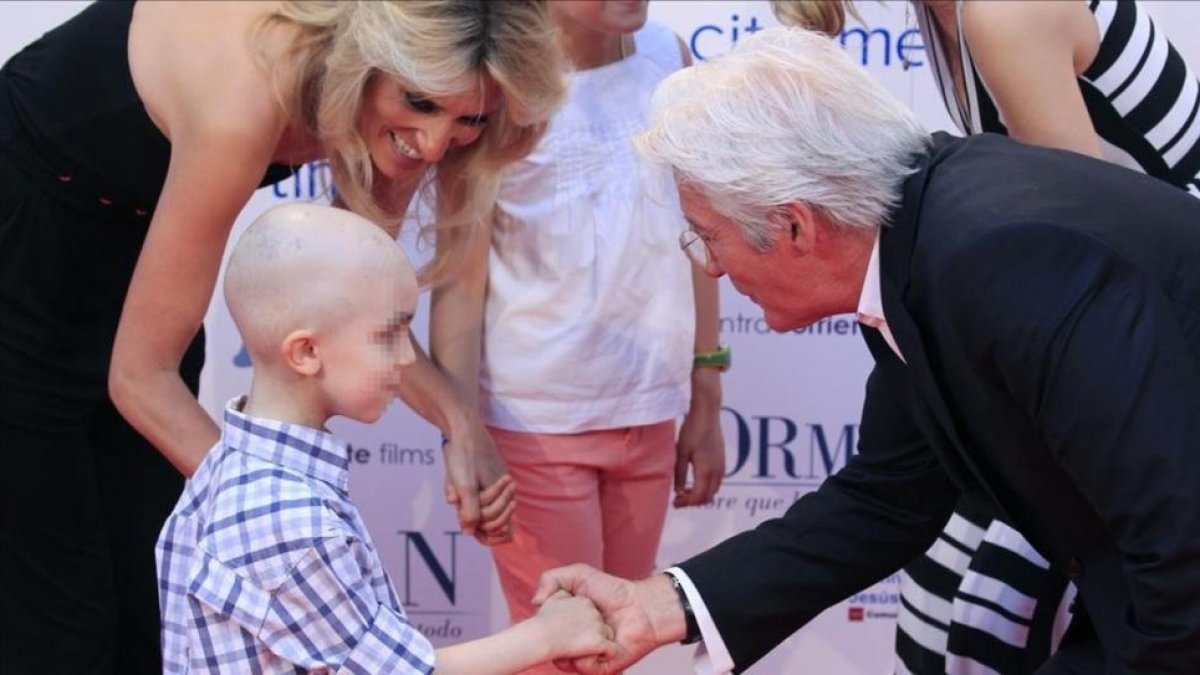 Richard Gere saluda a un niño enfermo en el estreno de 'Norman. El hombre que lo conseguía todo'.-EFE / VÍCTOR LARENA