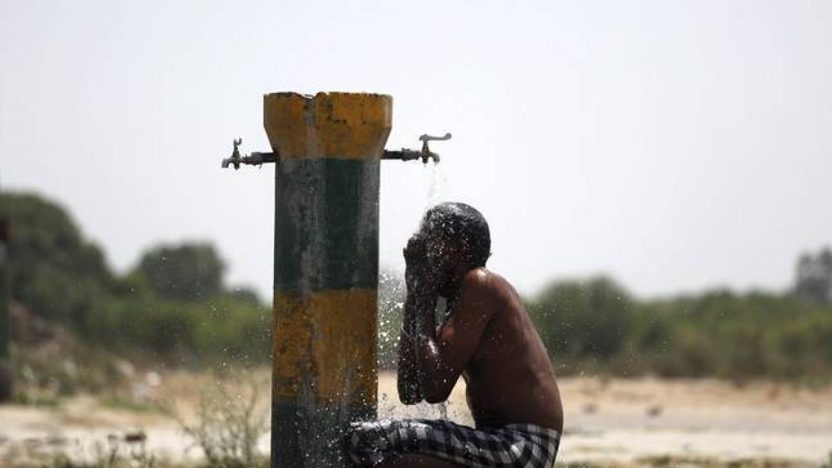 Un trabajador indio se refresca bajo un grifo una calurosa tarde en Amritsar (India).-Foto: EFE / RAMINDER PAL SINGH