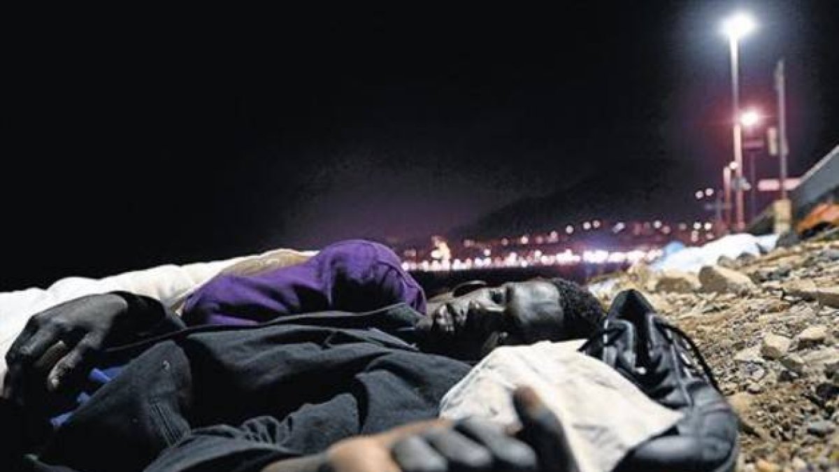 Un inmigrante africano duerme en el suelo, sobre unas piedras, cerca del mar en Ventimiglia, este lunes.-Foto: AP/ MASSIMO PINCA