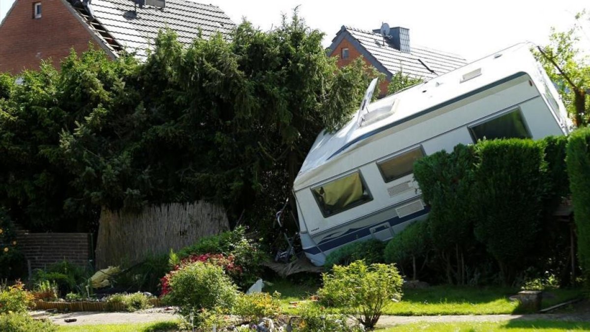 Una caravana derribada sobre un jardín tras el paso del tornado en el área de Boisheim, en el oeste de Alemania, este miércoles.-/ THILO SCHMUELGEN (REUTERS)