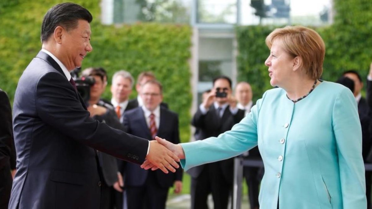 La cancillera alemana Angela Merkel da la bienvenida al presidente chino Xi Jinping.-AXEL SCHMIDT