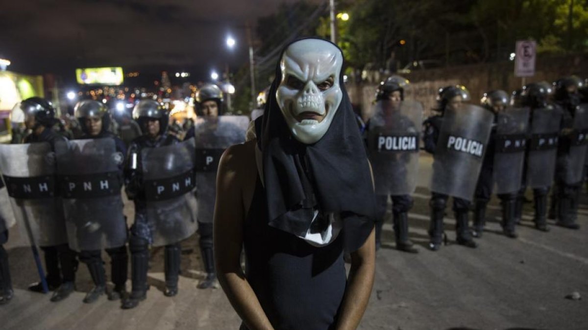 Un partidario de Salvador Nasralla ante la policía en Tegucigalpa (Honduras).-/ RODRIGO ABD (AP)